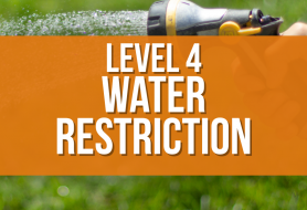 Level 4 Water Restriction in white letters on orange background on top of a picture of watering grass with a hose