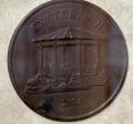 a photo showing a copper plate with the imprint of the band stand reading Exeter, NH on top and 2004 below