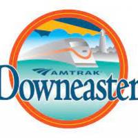 logo for amtrak downeaster with train inside of an orange circle with blue letters