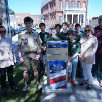 Eagle Scout Candidate James Haney stands with his Scout Troop in front of the flag retirement box