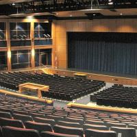 Exeter High School auditorium with many blue seats in front of a stage