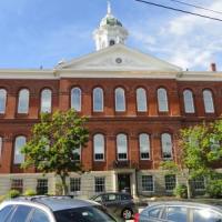 A picture of town hall as viewed from water street with the brick building in front of a blue sky