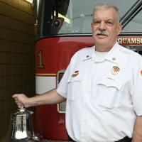 Fire Chief Eric Wilking stands in front of a fire engine