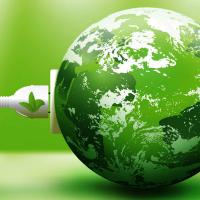 a white electric plug going into a green shaded earth globe with green background
