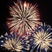 three fireworks exploding in a night sky