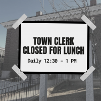 A picture of the Town Offices with a sign reading Town Clerk Closed for Lunch