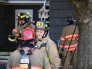 fire fighters talking outside of a home