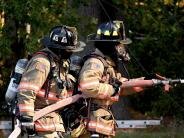 two fire fighters holding a water hose