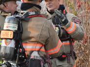 two firefighters talk outside of a building