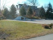 A side view of a skate ramp with two lower panels removed 