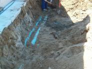 A construction worker digs to reach the water pipes under the park