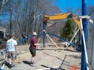 Workers on site lifting the roof beams of the pavilion 