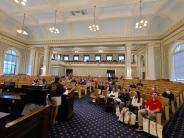 A crowd of people is addressed in the state house