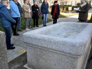 a group gathers around the trough to hear the history