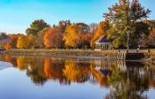 A picture of Swasey Parkway with fall leaves reflecting in the still water of the river