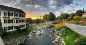 A photo of sunset over the falls of the Exeter River as seen from Great Bridge