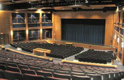 Exeter High School auditorium with many blue seats in front of a stage