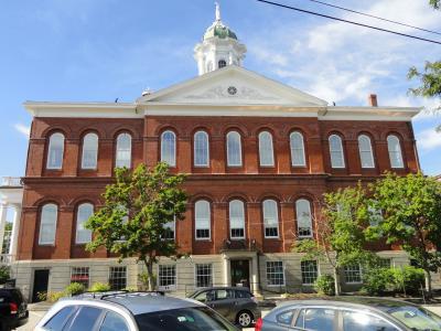 A picture of town hall as viewed from water street with the brick building in front of a blue sky