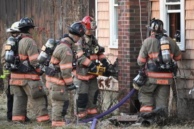 Exeter firefighters stand outside of a building