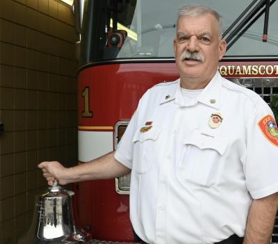 Fire Chief Eric Wilking stands in front of a fire engine