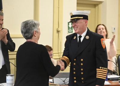 New Fire Chief Justin Pizon shakes hands with Town Clerk Andie Kohler after being sworn in