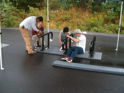 A small crew of young men works to get new skate rails in place