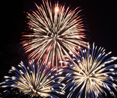 three fireworks exploding in a night sky